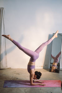 Full length of woman exercising on field