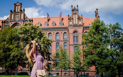 Woman standing against palace in city