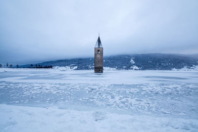 Scenic view of bell tower on a frozen lake during winter