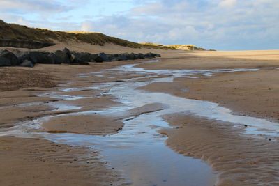 Landscape sandy beach blue pink skies reflected in sea water pools ocean tide norfolk east anglia uk