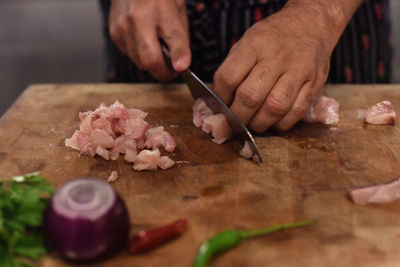 Cropped hands of woman chopping vegetables on cutting board at home