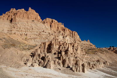 Rock formations in desert against clear blue sky