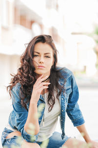 Portrait of beautiful young woman sitting outdoors