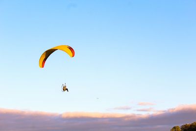 Person paragliding against sky