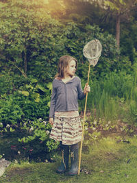 Girl standing in garden with bag net