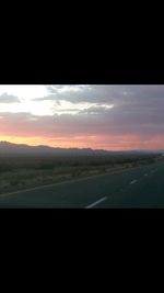 Scenic view of landscape against dramatic sky during sunset