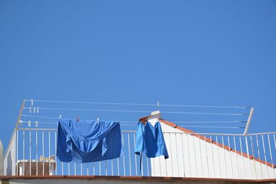 Low angle view of blue fabrics drying on clothesline