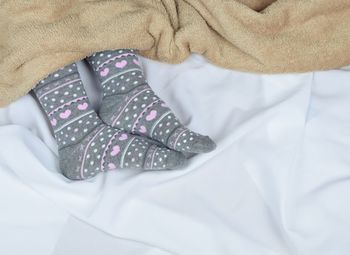 Low section of person wearing socks while lying on bed