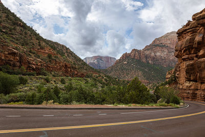 Road leading towards mountains against sky