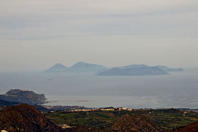 Scenic view of sea and mountains against sky