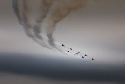 Low angle view of airshow against sky