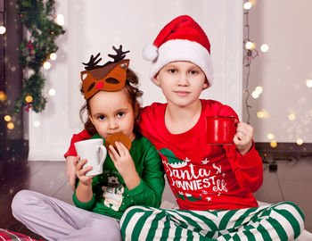 Portrait of cute sibling drinking milk at home