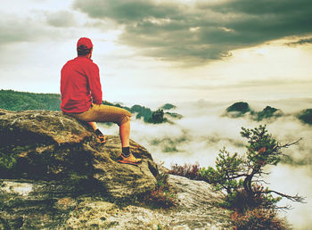 Man observe fall daybreak on peak of rock empire. dreamy foggy valley of saxony switzerland park.