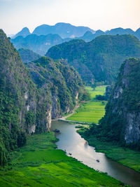 Scenic view of river amidst mountains against sky