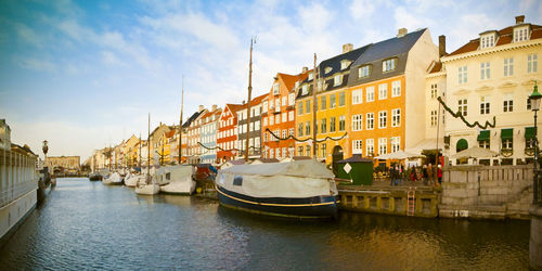 Boats in canal amidst buildings in city