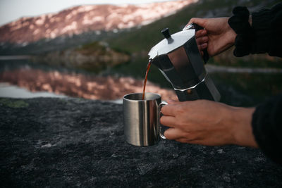 Midsection of man holding coffee