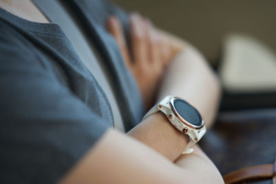 Midsection of woman wearing wristwatch in car