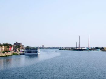 City buildings by sea against clear sky