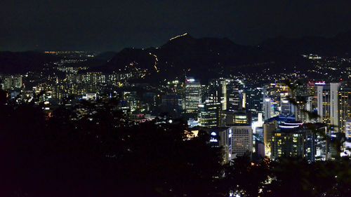 High angle view of illuminated buildings against sky at night