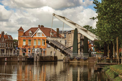 Brick houses, boats and bascule bridge in canal at weesp. a pleasant small village in netherlands.