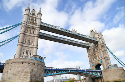 Low angle view of tower bridge over thames river against cloudy sky