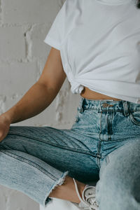 Midsection of girl in blue jeans and white t-shirt