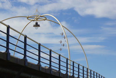 Low angle view of railing against sky at airshow