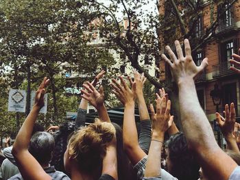 Group of people with arms raised in city