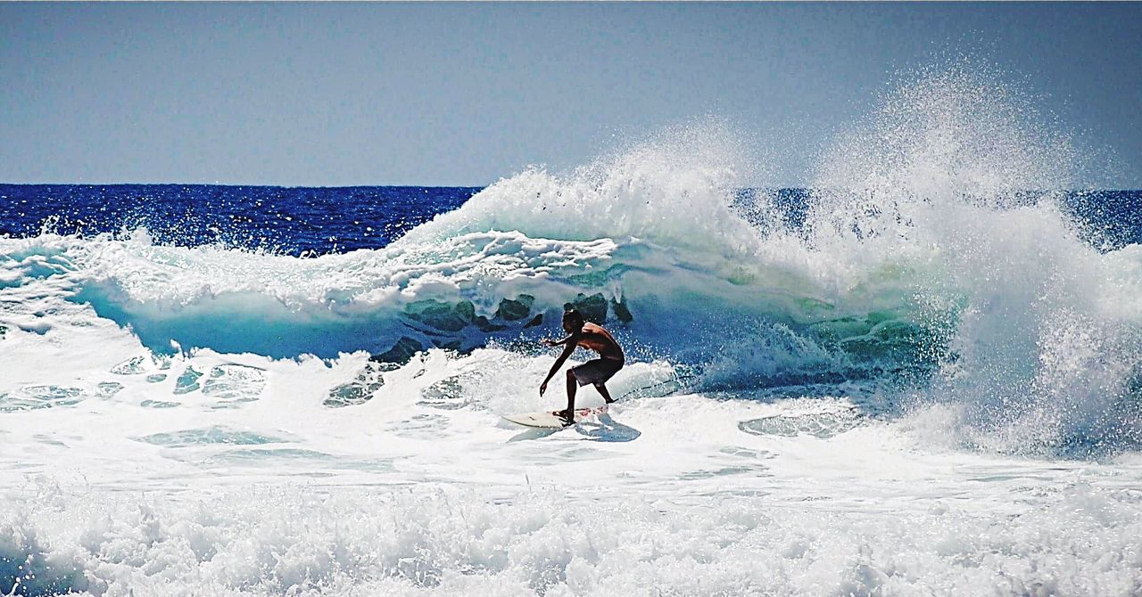 FULL LENGTH OF MAN SPLASHING WATER IN SEA