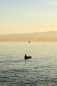 Silhouette boat in sea against sky during sunset