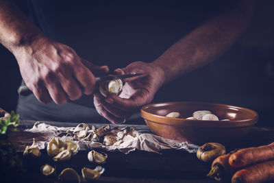 Cropped image of chef cutting mushroom on table