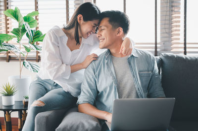 Young couple sitting on sofa at home