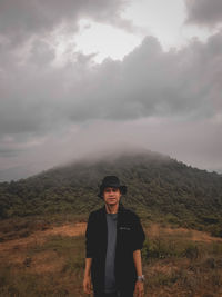 Portrait of man standing on land against sky