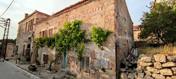 Graffiti on wall by building against sky