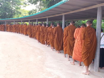 Rear view of people walking on footpath