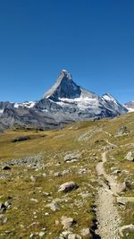 Scenic view of snowcapped mountains against clear blue sky