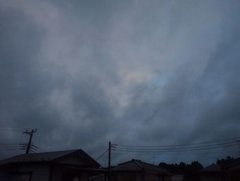 Low angle view of silhouette houses against sky