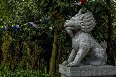 Lion statue against trees at bacalhoa buddha eden