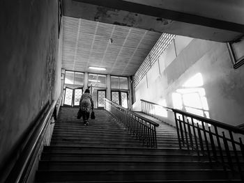 Rear view of man walking on staircase