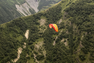 High angle view of person paragliding over mountains