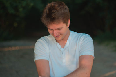 Close-up of handsome young man standing at park