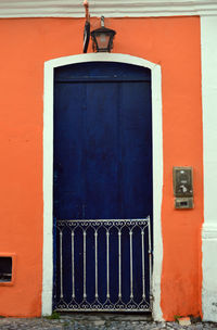 Blue closed door on orange wall