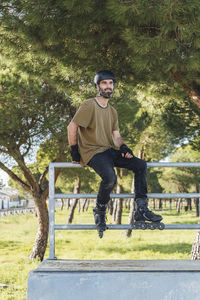 Portrait of young man against trees in park