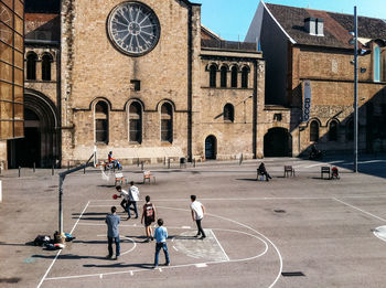 High angle view of boys playing at basketball court during sunny day