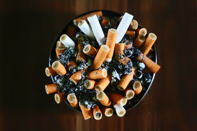 Close-up of cigarette butts in ashtray on table