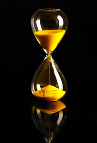 Close-up of yellow clock on glass