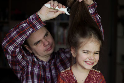 Portrait of smiling mother and daughter at home