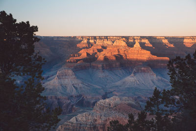 Scenic view of eroded landscape against clear sky during sunset