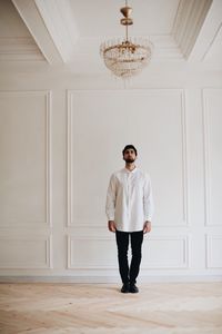 Full length of young man standing against wall