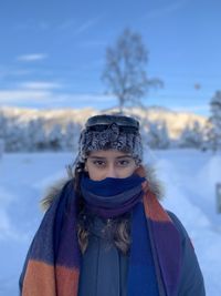 Portrait of woman covering face with snow